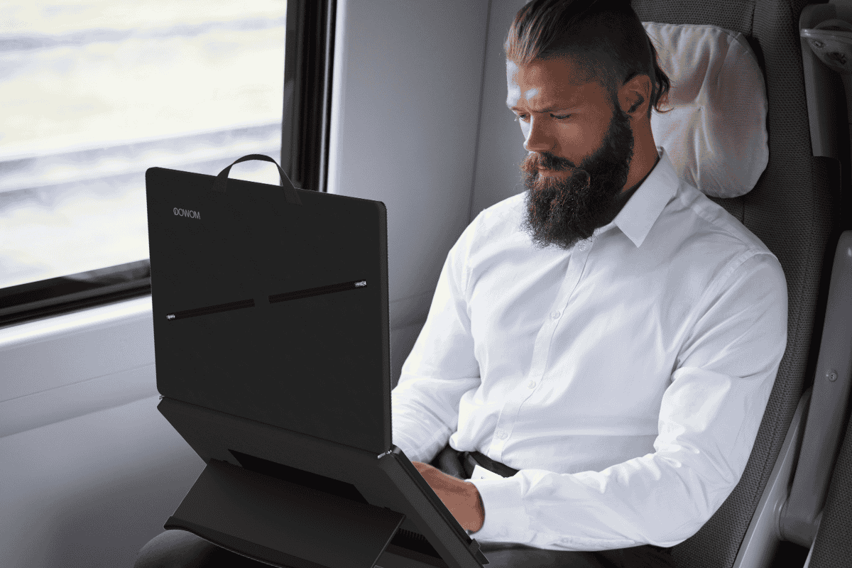 A man using a Mowoq productivity laptop bag while travelling.